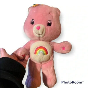Rainbow Care Bear that’s pink with a rainbow on the front of bear